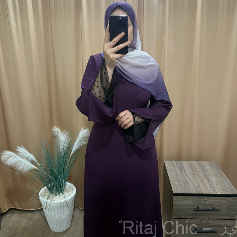 فستان طويل بتصميم أنيق وأكمام واسعة مزينة بتول شفاف منقّط